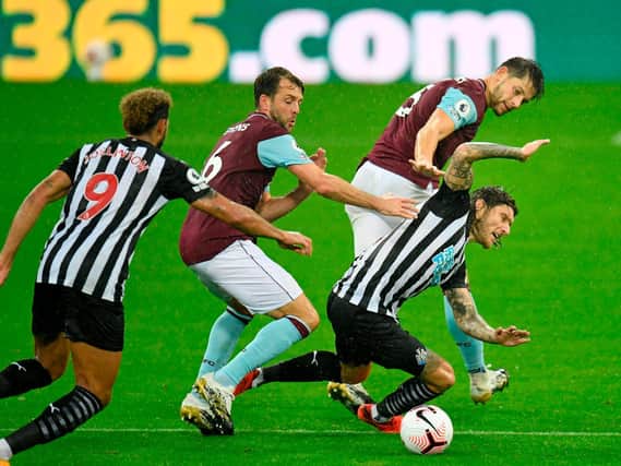 Newcastle United's Irish midfielder Jeff Hendrick is tackled by Burnley's English defender James Tarkowski (back) and Dale Stephens (2nd L) during the English Premier League football match between Newcastle United and Burnley at St James' Park in Newcastle-upon-Tyne, north east England on October 3, 2020. (Photo by PETER POWELL / POOL / AFP)