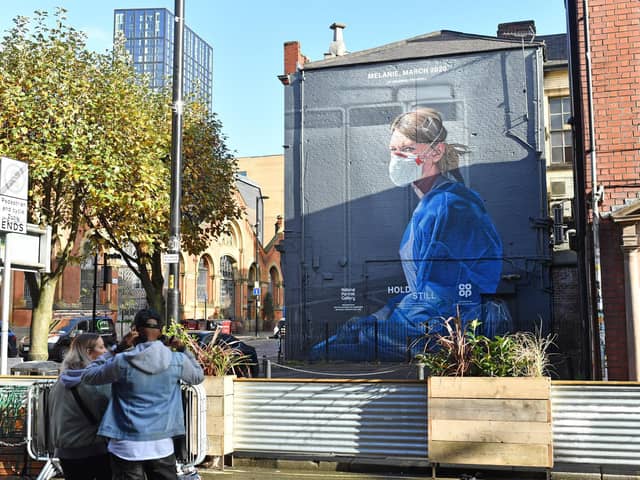 A mural depicting a health worker by artist Peter Barber in Manchester