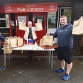 Ben Anglesea and Darryl Latham, from Wigan Eats, hand out lunches with Chris Mason, headteacher at Sacred Heart Catholic Primary School, Beech Hill