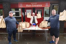 Ben Anglesea and Darryl Latham, from Wigan Eats, hand out lunches with Chris Mason, headteacher at Sacred Heart Catholic Primary School, Beech Hill