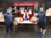 Ben Anglesea and Darryl Latham, from Wigan Eats, hand out lunches with Chris Mason, headteacher at Sacred Heart Catholic Primary School, Beech Hill