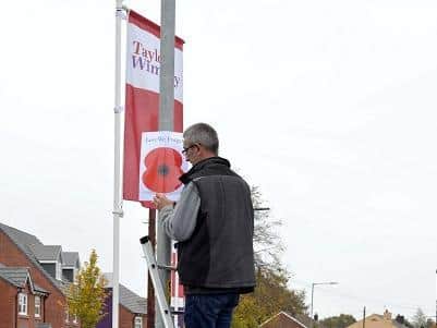 A volunteer putting up one of the posters only last month