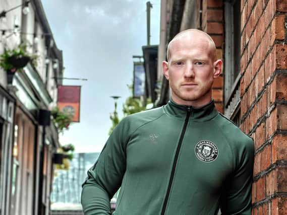 Liam Farrell models a top with the new logo