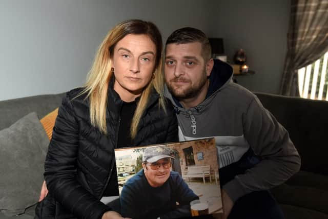 Louise Hodson, holding a photograph of her father Harry Ormisher, with her husband Craig Hodson