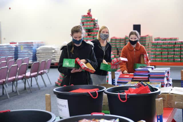 Volunteers pack the boxes with gifts