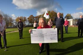Lady captain Elaine King, centre, holds a £1,000 cheque for Breast Cancer Now charity, pictured with club captain Ben Johnson and other members of Gathurst Golf Club - the funds were raised at charity golf competitions and some competitors wore pink