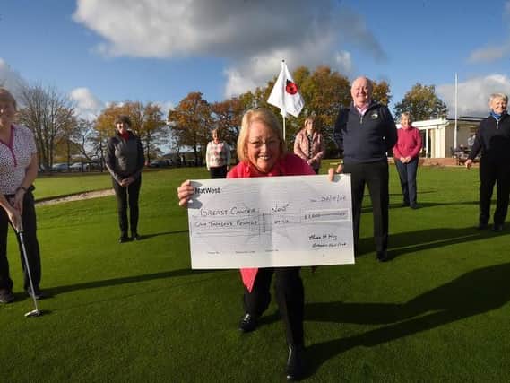 Lady captain Elaine King, centre, holds a £1,000 cheque for Breast Cancer Now charity, pictured with club captain Ben Johnson and other members of Gathurst Golf Club - the funds were raised at charity golf competitions and some competitors wore pink