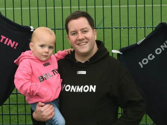 Craig Smart from Standish with daughter Heidi, two, wearing some of the hoodies printed with Wigan sayings, part of his new clothing brand, Alsithi