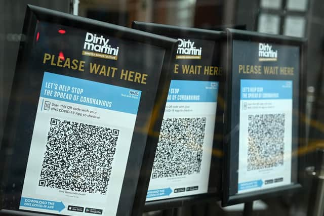 Track and trace QR codes are displayed outside a pub, in Manchester