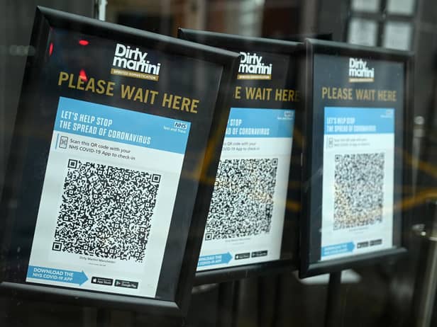 Track and trace QR codes are displayed outside a pub, in Manchester