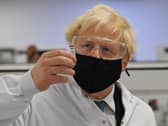 Britain's Prime Minister Boris Johnson poses for a photograph with a vial of the AstraZeneca/Oxford University COVID-19 candidate vaccine, known as AZD1222, at Wockhardt's pharmaceutical manufacturing facility in Wrexham, north Wales, on November 30, 2020.