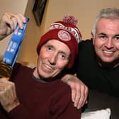 Joe Bennett holding the medal Wigan Warriors gave him, with his son Scott