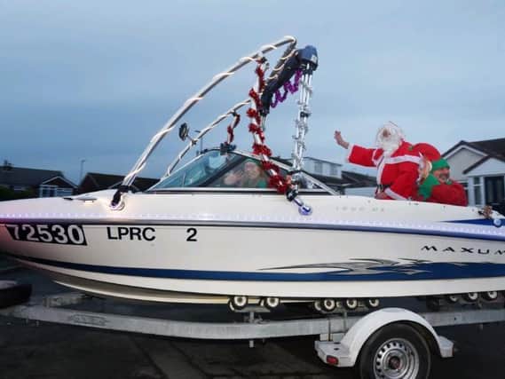 Roy Battarbee, right, with friends on his speed boat converted to Santa’s sleigh