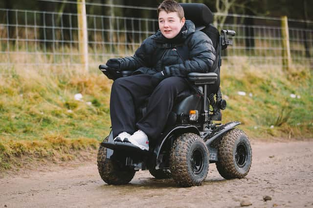 Thomas tests out his new wheelchair. Image courtesy of Tom Gradwell Photography
