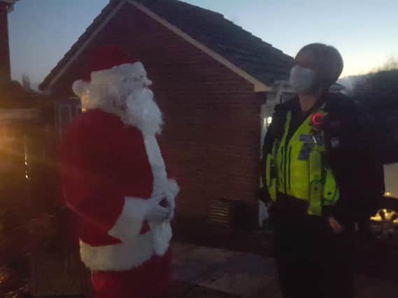Mike Denaro, dressed as Father Christmas, talking to a police officer