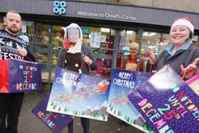 Staff at the Co-op shop in Orrell, from left, Tom Fitchett, Melissa Guy, Sue Allan and Sharon Perree, with some of the many gifts, toys and food packages they have given to families of children at Dean Trust schools