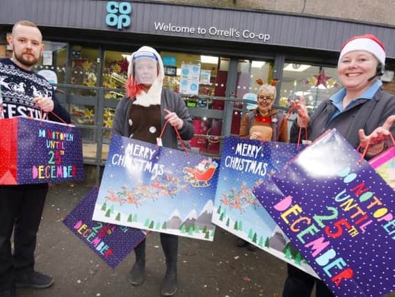 Staff at the Co-op shop in Orrell, from left, Tom Fitchett, Melissa Guy, Sue Allan and Sharon Perree, with some of the many gifts, toys and food packages they have given to families of children at Dean Trust schools