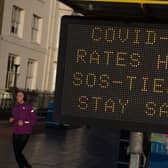 A member of public walks past a public safety notice that reads "Covid-19 Rates High, SOS-Tier 4, Stay Safe" on the high street on December 20, 2020 in Southend on Sea.
