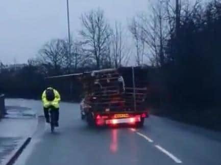The cyclist is narrowly missed by the falling pallets