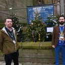 Pictured from left, are Coun Jamies Hodgkinson and James Watson, next to some of the 11 Christmas trees primary school children have decorated outside St John the Baptist's Church in Atherton town centre.
