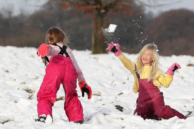 Ruby Millington (left) and Molly Chamberlain play in the snow at Tatton Park, Knutsford