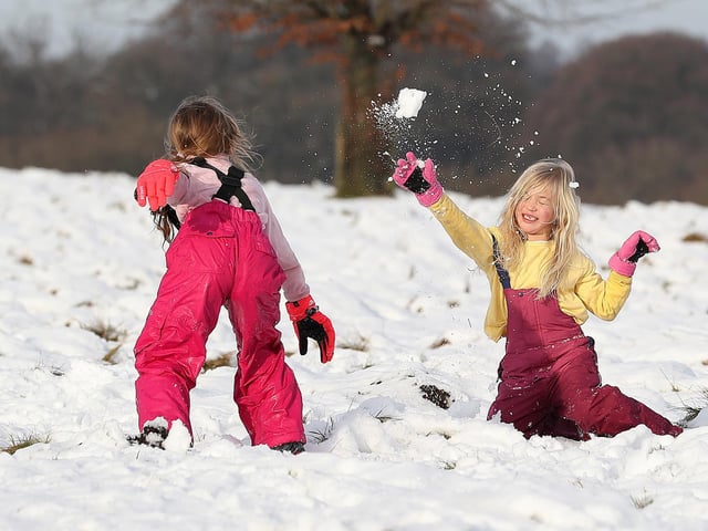 Ruby Millington (left) and Molly Chamberlain play in the snow at Tatton Park, Knutsford