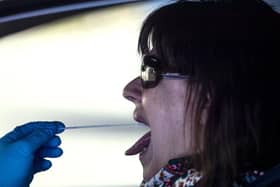 A woman undergoes a PCR throat swab (AP Photo: Manu Fernandez)