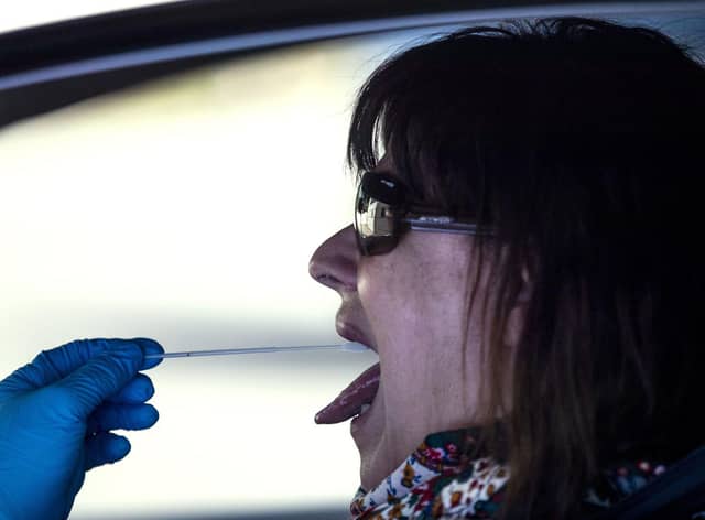 A woman undergoes a PCR throat swab (AP Photo: Manu Fernandez)