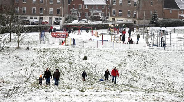 Families enjoy the snow in Buckshaw Village, near Chorley, earlier this week. North West Ambulance Service is urging people to be careful in the ice and snow after a recent spike in calls to the service