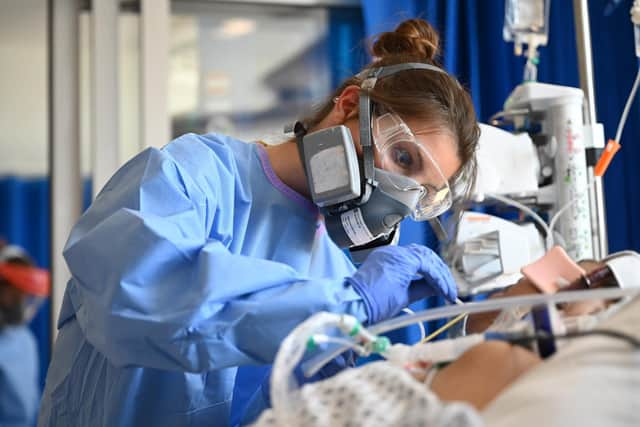 Clinical staff wear Personal Protective Equipment (PPE) as they care for a patient in intensive care