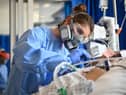 Clinical staff wear Personal Protective Equipment (PPE) as they care for a patient in intensive care