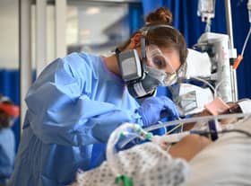 Clinical staff wear Personal Protective Equipment (PPE) as they care for a patient in intensive care