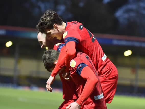 Will Keane is mobbed after his late goal which put Latics 3-2 up