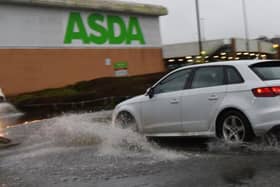 A roundabout at Asda supermarket and entrance to Robin Retail Park, Wigan, is flooded