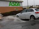 A roundabout at Asda supermarket and entrance to Robin Retail Park, Wigan, is flooded