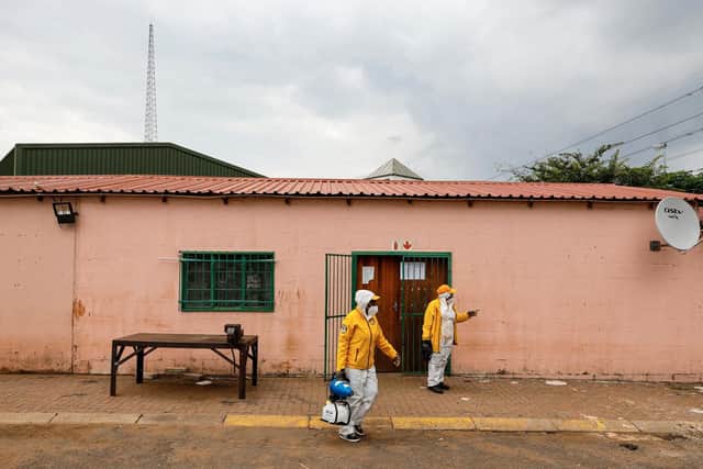 Two volunteers walk away from an office that has just been disinfected during a deep cleaning operation inside a garage where a recent COVID-19 case was detected, in Ekurhuleni, South Africa