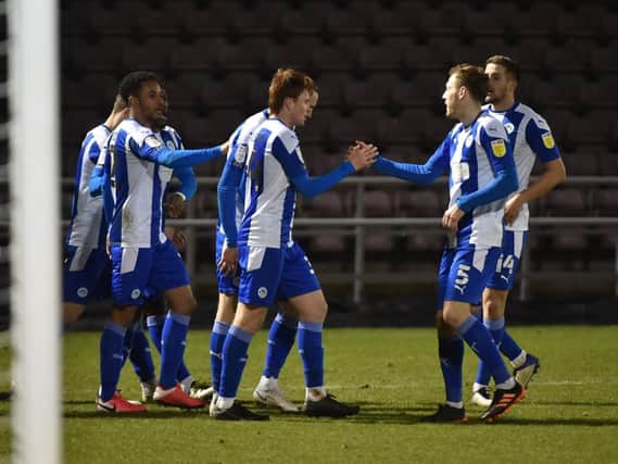 The Latics players celebrate their victory at Northampton in midweek