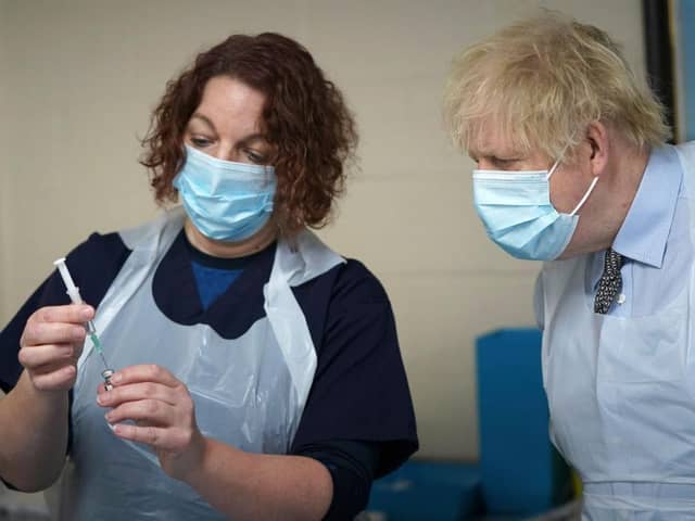 Prime Minister Boris Johnson is shown how to prepare the vaccine by advance nurse practitioner Sarah Sowden as he visits a COVID-19 vaccination centre