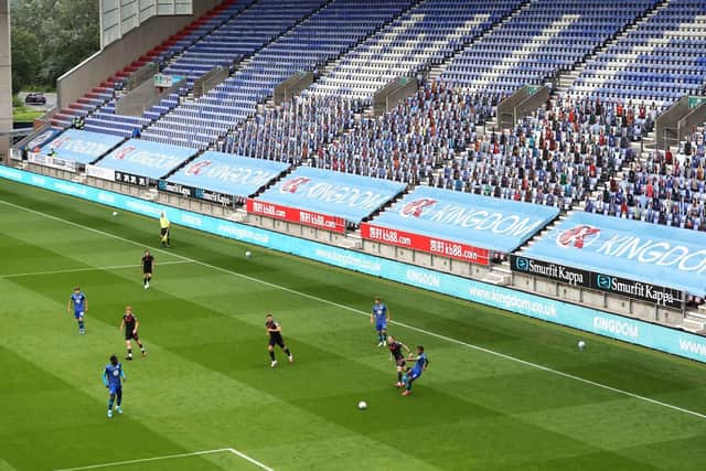 Latics playing in front of cardboard cutouts