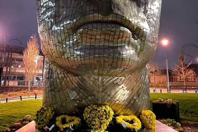 The flowers at the base of the sculpture in Wigan town centre