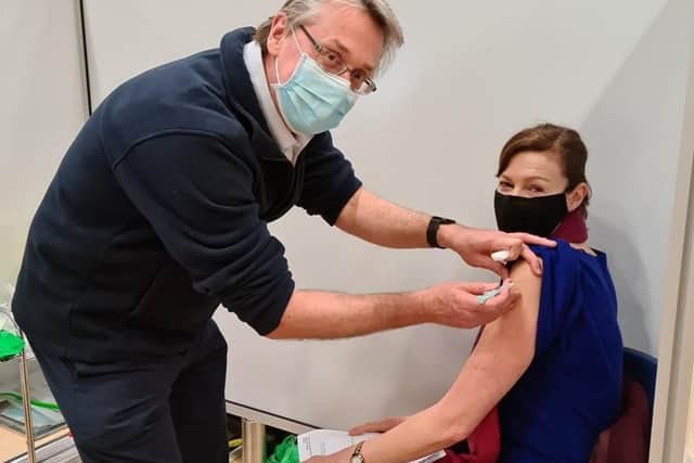 Dr Tim Dalton vaccinating Nichola Gibbons with approximately the 100,000th jab