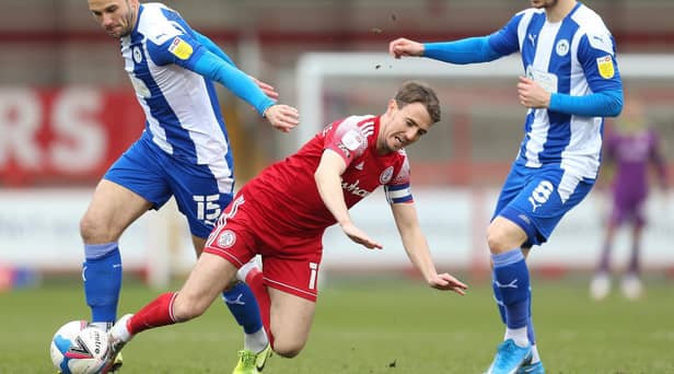 Sean McConville of Accrington Stanley is challenged by Dan Gardner of Wigan Athletic during the Sky Bet League One match between Accrington Stanley and Wigan Athletic at The Crown Ground on March 20, 2021 in Accrington, England.