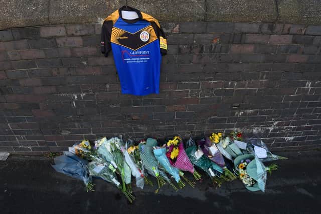 Flowers and a rugby shirt have been left at the scene