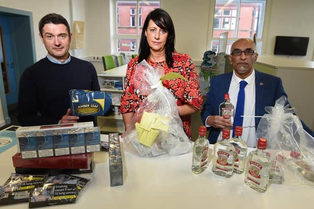 Trading standards manager Ian Kelsall, Julie Middlehurst, assistant director for infrastructure and regulatory services at Wigan Council, and trading standards officer Abdul Bari with some of the counterfeit goods they have seized