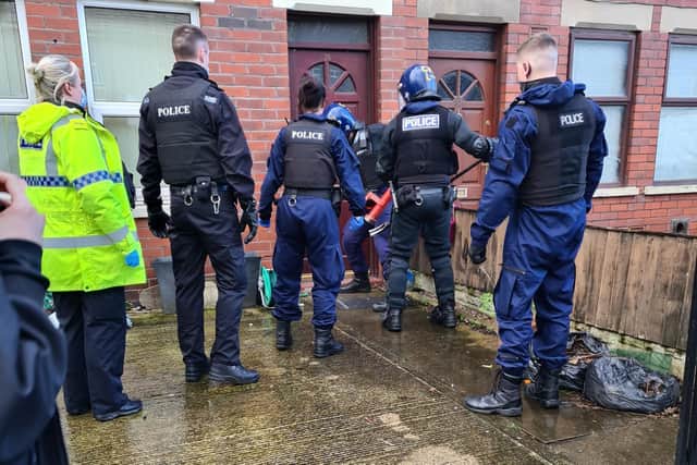 Officers use a battering ram to get into the Diamond Street house