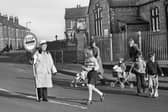 Liverpool Road, Platt Bridge, in 1976 and lollipop lady Mrs. Hargreaves shepherds kids and mums across from the old St. Nathaniel's Primary School.