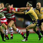 WIGAN, ENGLAND - 2 SEPTEMBER 2005:  Danny Tickle of Wigan breaks between Matt Diskin (L) and Kevin Sinfield (R) during the Engage Super League match between Wigan Warriors and Leeds Rhinos at the JJB Stadium on September 2, 2005 in Wigan, England