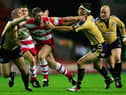 WIGAN, ENGLAND - 2 SEPTEMBER 2005:  Danny Tickle of Wigan breaks between Matt Diskin (L) and Kevin Sinfield (R) during the Engage Super League match between Wigan Warriors and Leeds Rhinos at the JJB Stadium on September 2, 2005 in Wigan, England