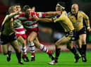 WIGAN, ENGLAND - 2 SEPTEMBER 2005:  Danny Tickle of Wigan breaks between Matt Diskin (L) and Kevin Sinfield (R) during the Engage Super League match between Wigan Warriors and Leeds Rhinos at the JJB Stadium on September 2, 2005 in Wigan, England