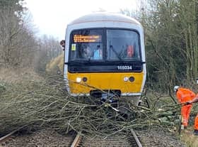 Workers clearing branches of a tree from the tracks after Storm Eunice